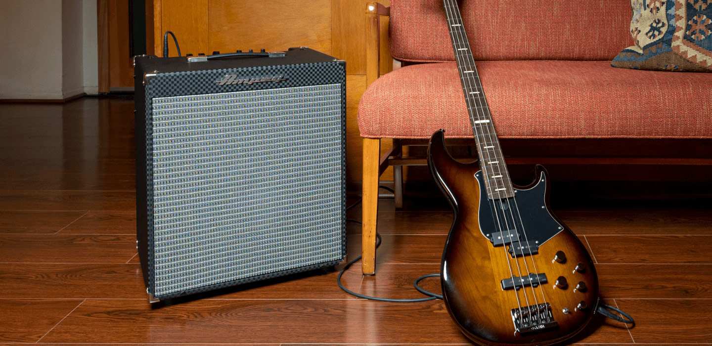 Ampeg RB-112 sitting next to a red couch with bass guitar