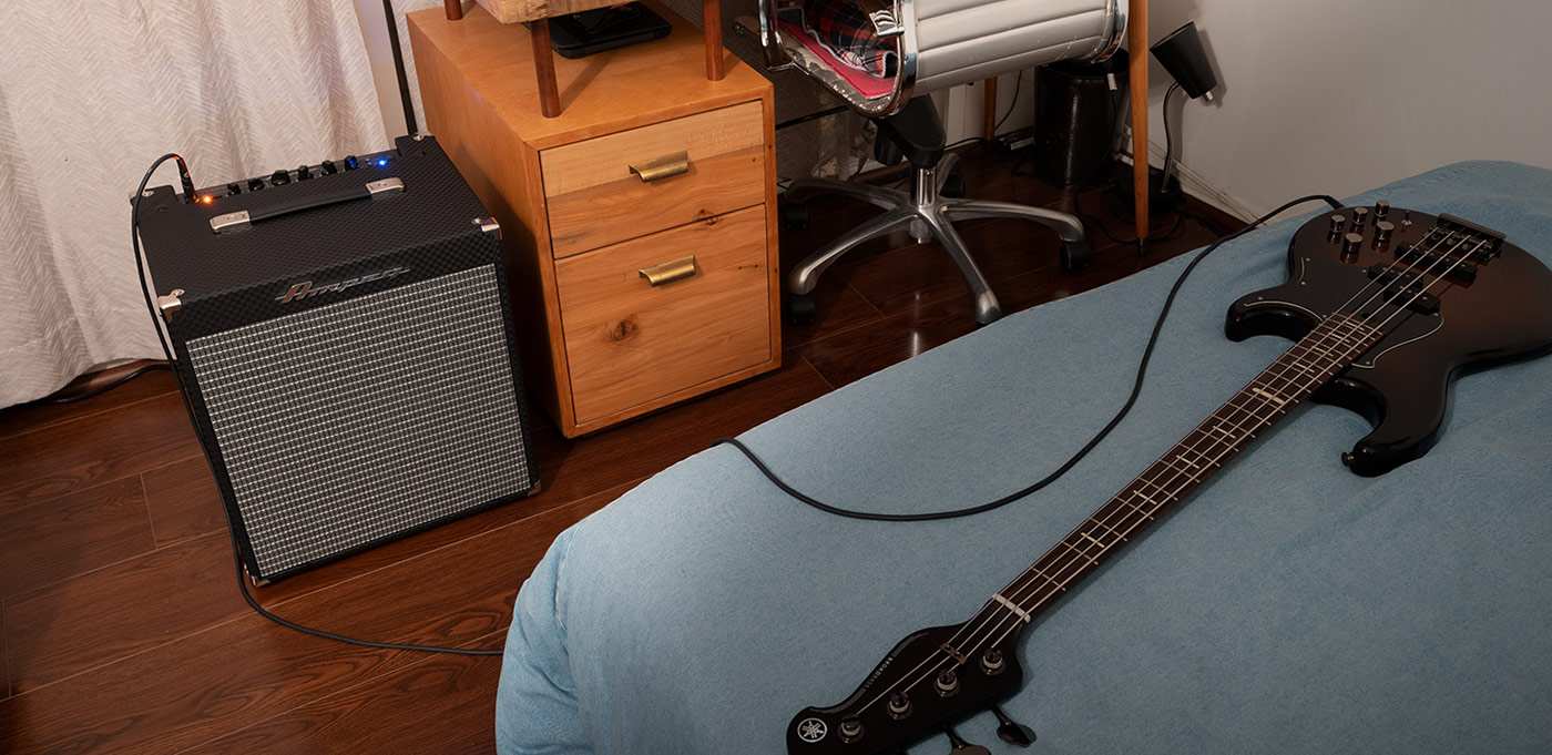 Ampeg RB-110 in small bedroom next to desk. Bass Guitar on bed