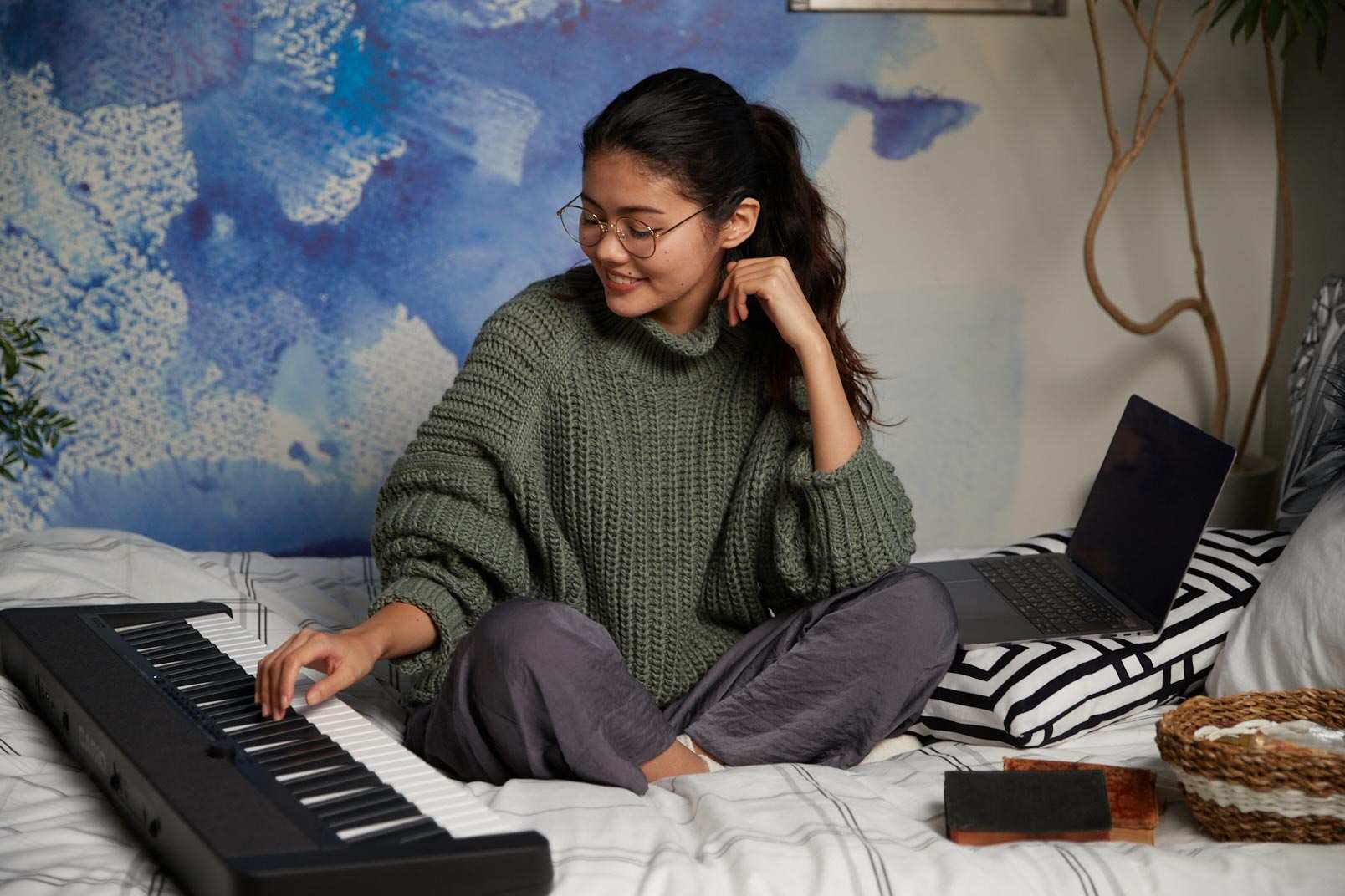 Girl Playing Casio Keyboard on Bed with laptop