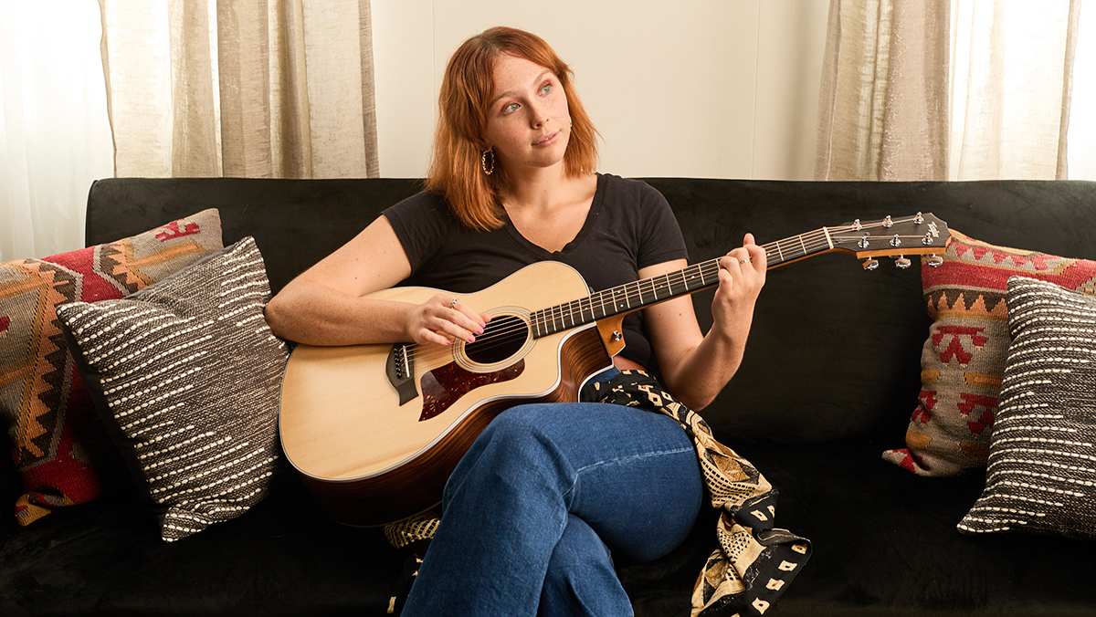 Woman playing 214ce on a couch