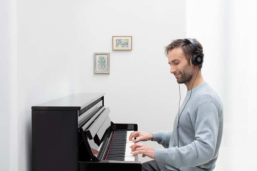 Person playing Yamaha CLP-785 with Headphones