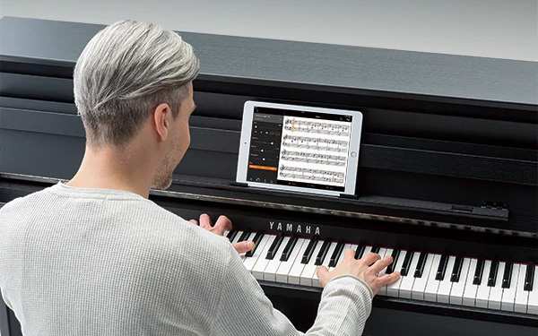 Person Playing Yamaha Digital Piano with iPad App on Music Rest