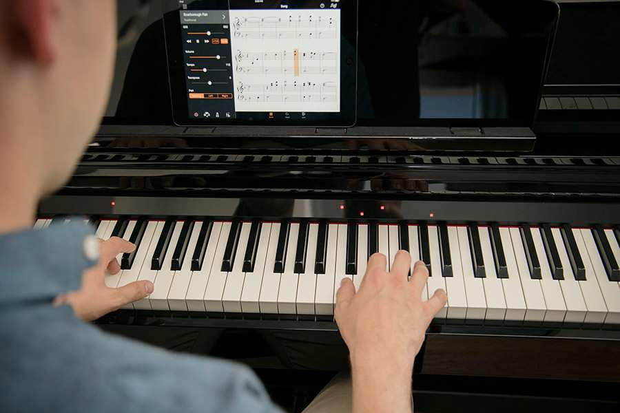Person playing Yamaha CSP Clavinova with iPad Scoring