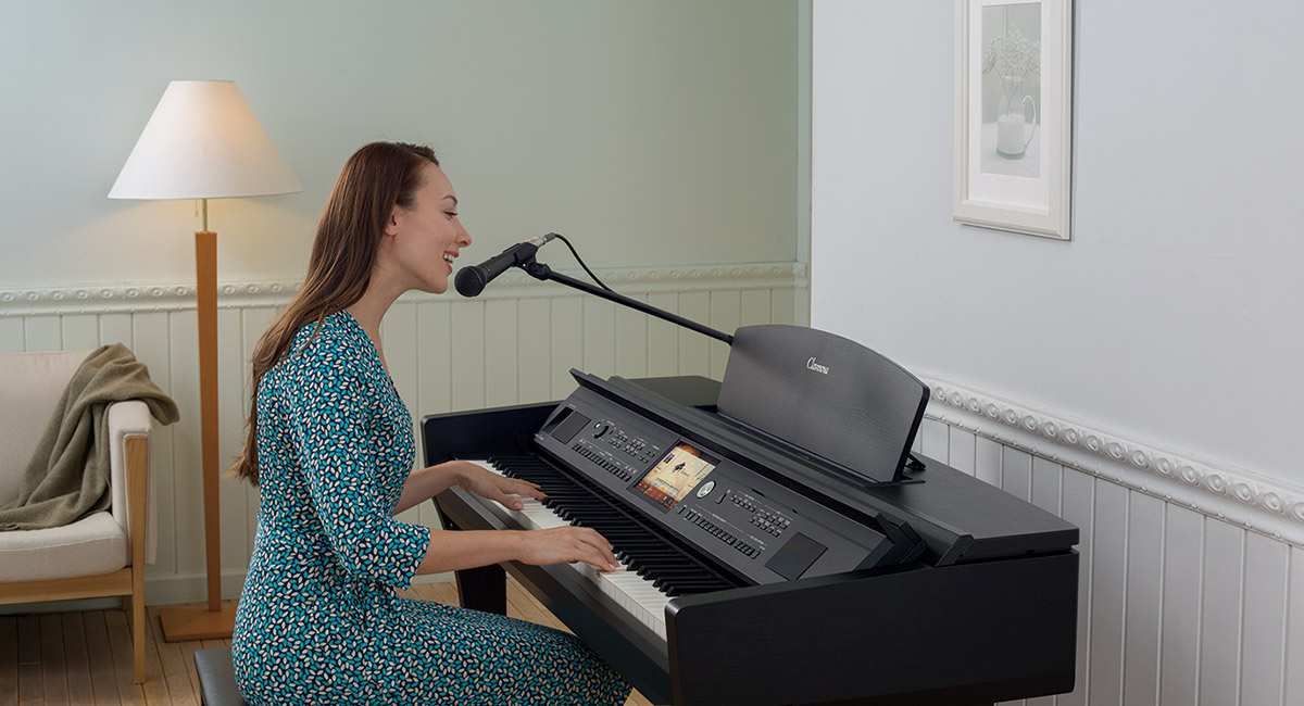 person playing CVP Clavinova and singing into microphone in home environment