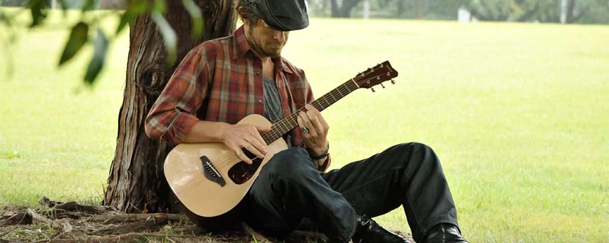 Man playing Yamaha JR1 in a park by a tree